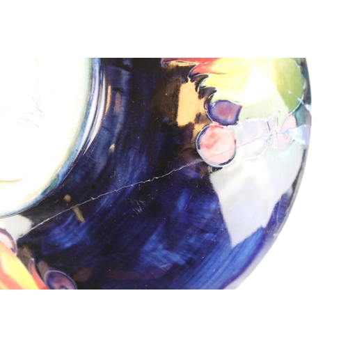 22 - A blue ground Moorcroft bowl with leaf and berry decoration af and a similar green ground bowl with ... 