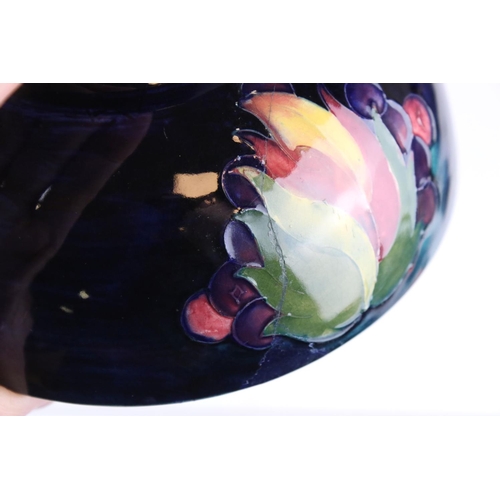 22 - A blue ground Moorcroft bowl with leaf and berry decoration af and a similar green ground bowl with ... 