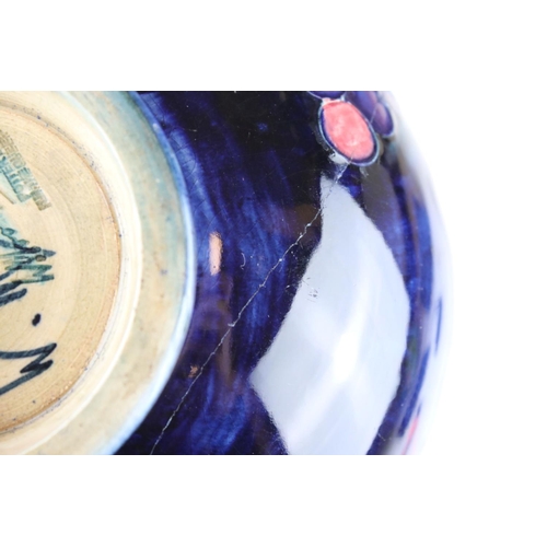 22 - A blue ground Moorcroft bowl with leaf and berry decoration af and a similar green ground bowl with ... 