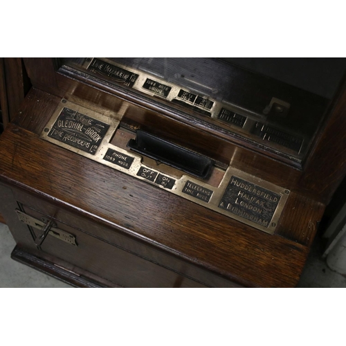 38 - An early 20th century oak cased Gledhill Brook Time Recorder clocking in clock together with a wall ... 