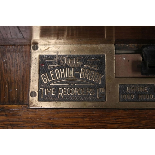 38 - An early 20th century oak cased Gledhill Brook Time Recorder clocking in clock together with a wall ... 