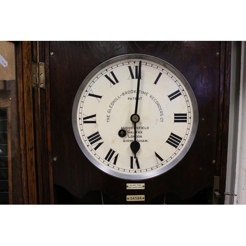 38 - An early 20th century oak cased Gledhill Brook Time Recorder clocking in clock together with a wall ... 