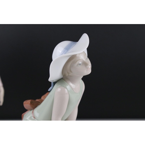 12 - Three Lladro figures to include Girl holding chicken, Girl looking coy and Girl holding doll.