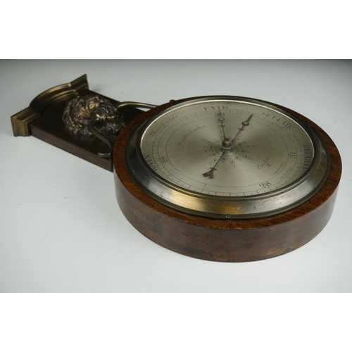 53 - An early 20th century oak cased barometer with lion mask decoration.