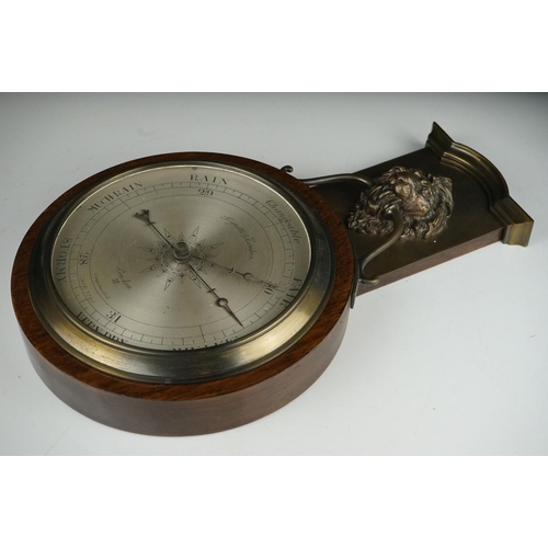 53 - An early 20th century oak cased barometer with lion mask decoration.