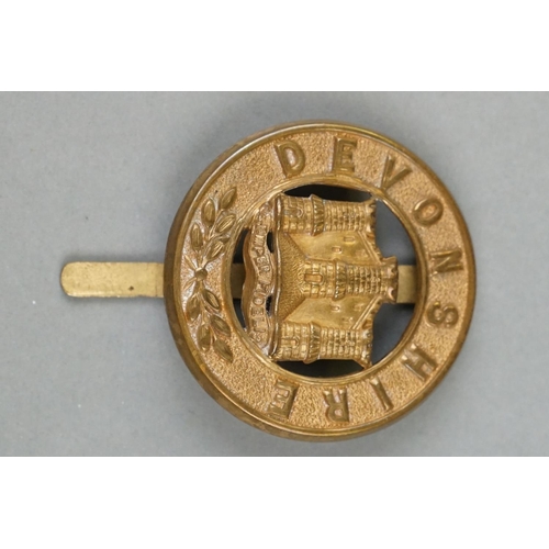 27 - A British Military The Devonshire Regiment Brass Pagri Badge With Large Slider Fixing Too Verso.
