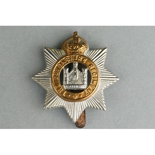 75 - A British Military The Devonshire Regiment Bi Metal Cap Badge With Slider Fixing To Verso Together W... 