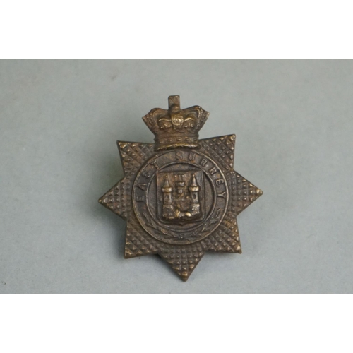 205 - A British Military East Surrey Regiment Bronze Cap Badge With Queen Victoria Crown, Twin Loop Fixing... 