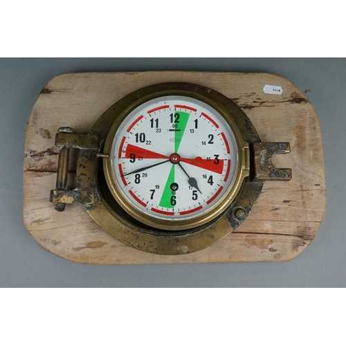 231 - A Ships Marine Clock By Tempora, Mounted Within A Brass Porthole, Made In Great Britain.