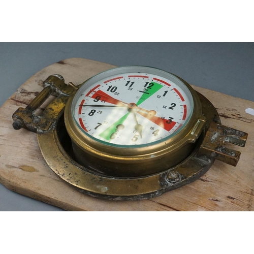 231 - A Ships Marine Clock By Tempora, Mounted Within A Brass Porthole, Made In Great Britain.