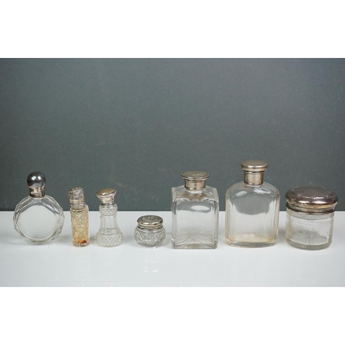 315 - A collection of vintage silver topped scent bottles to include hallmarked examples.