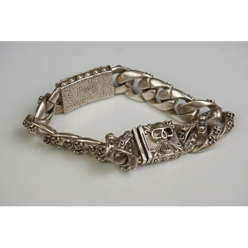336A - A white metal curb link bracelet with skull clasp and decoration.