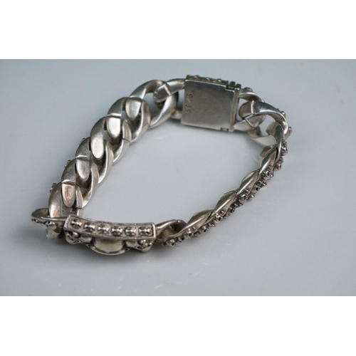 336A - A white metal curb link bracelet with skull clasp and decoration.