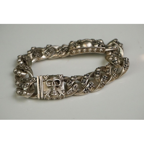 336A - A white metal curb link bracelet with skull clasp and decoration.
