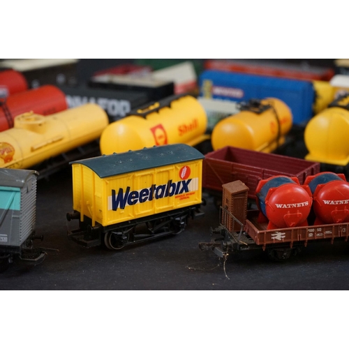 46 - Around 55 OO gauge items of rolling stock to include wagons, tankers, flatbeds and trucks featuring ... 