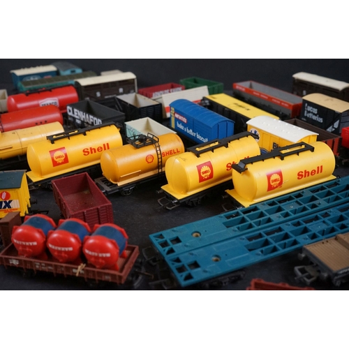 46 - Around 55 OO gauge items of rolling stock to include wagons, tankers, flatbeds and trucks featuring ... 