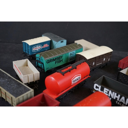 46 - Around 55 OO gauge items of rolling stock to include wagons, tankers, flatbeds and trucks featuring ... 