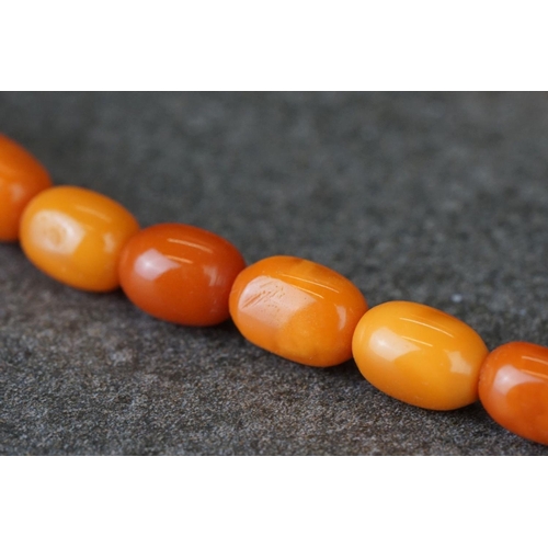 209 - A hand strung amber beaded flapper necklace.