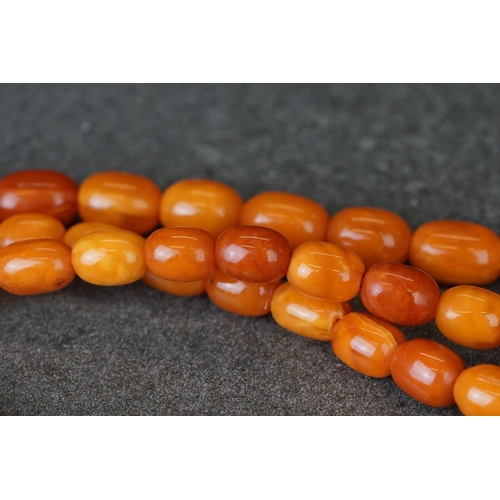 209 - A hand strung amber beaded flapper necklace.