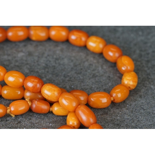 209 - A hand strung amber beaded flapper necklace.