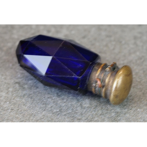 214 - A small group of collectables to include a blue glass scent bottle, watch winder and a pin cushion.