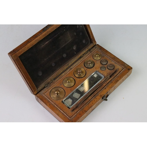 98 - A set of early 20th century balance scales together with a cased set of brass weights.
