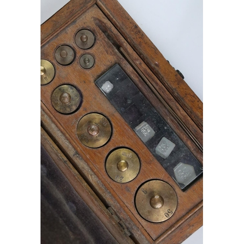 98 - A set of early 20th century balance scales together with a cased set of brass weights.