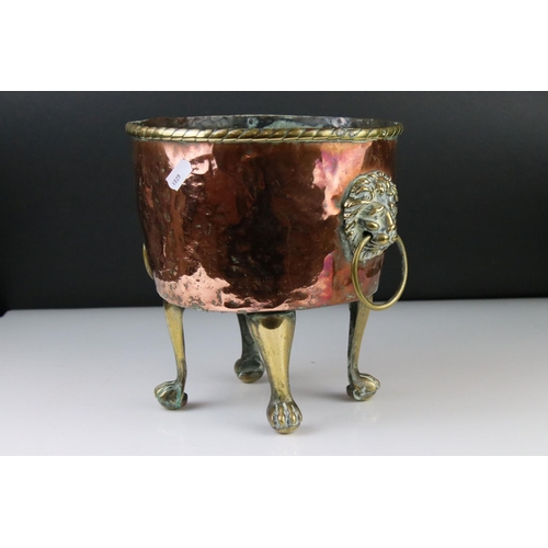 102 - Copper Circular Planter with two brass ringed lion mask handles and raised on four tall brass lion p... 