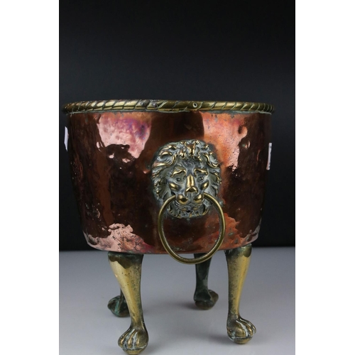 102 - Copper Circular Planter with two brass ringed lion mask handles and raised on four tall brass lion p... 