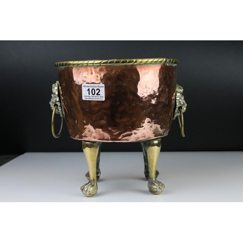 102 - Copper Circular Planter with two brass ringed lion mask handles and raised on four tall brass lion p... 