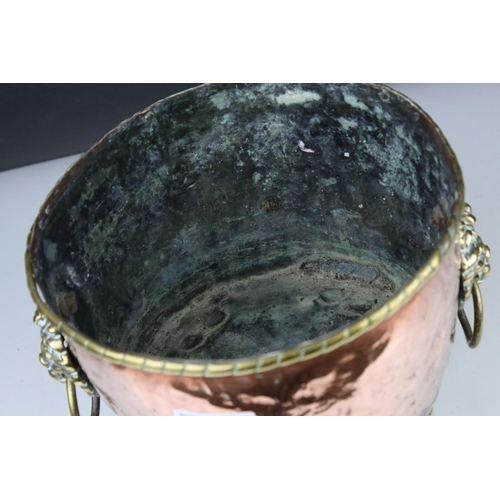 102 - Copper Circular Planter with two brass ringed lion mask handles and raised on four tall brass lion p... 