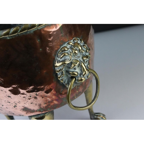 102 - Copper Circular Planter with two brass ringed lion mask handles and raised on four tall brass lion p... 