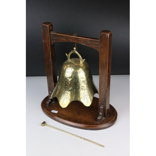 108 - Brass engraved Temple Bell with striker held on a Hardwood Stand, 34cm high