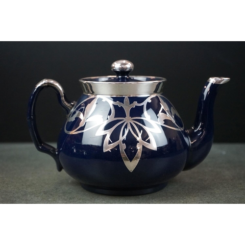28 - Blue Glazed Pottery Tea Service comprising Teapot, Lidded Sugar and Milk Jug, with white metal overl... 
