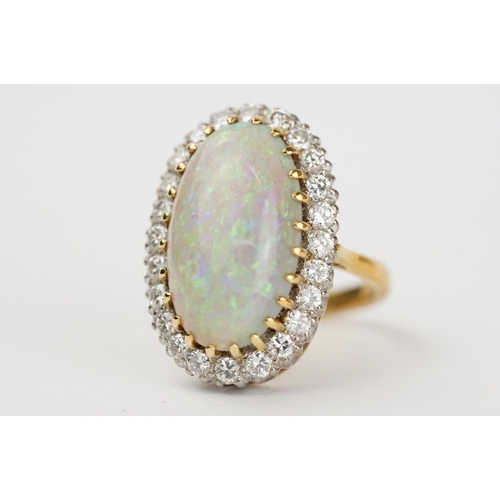 20 - Opal and diamond 18ct yellow gold and white gold set cluster ring, the large oval cabochon cut preci... 