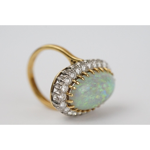 20 - Opal and diamond 18ct yellow gold and white gold set cluster ring, the large oval cabochon cut preci... 