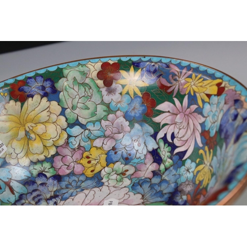 129 - An oriental copper bowl with floral cloisonné decoration.