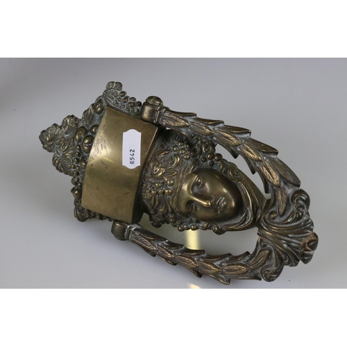 141 - A victorian door knocker of classical form together with a cast metal ewer.