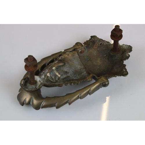 141 - A victorian door knocker of classical form together with a cast metal ewer.