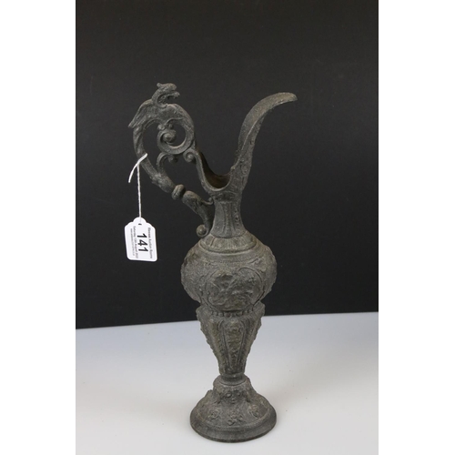 141 - A victorian door knocker of classical form together with a cast metal ewer.