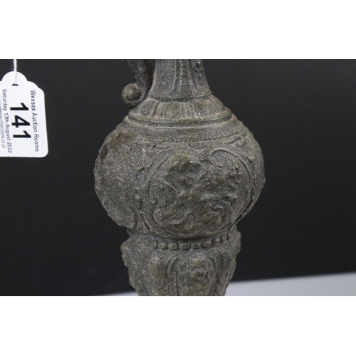 141 - A victorian door knocker of classical form together with a cast metal ewer.