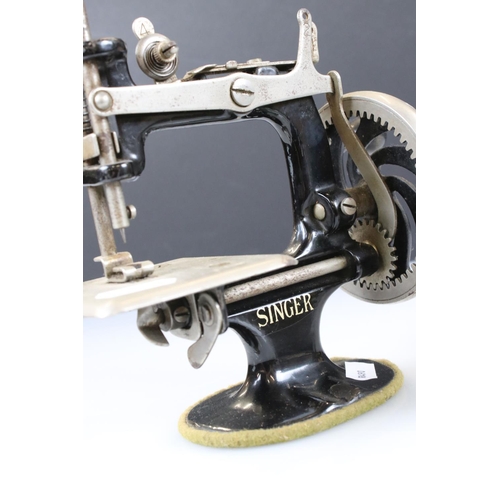 145 - An antique cast iron miniature Singer sewing machine together with a miniature A.R.C. Chesterton iro... 