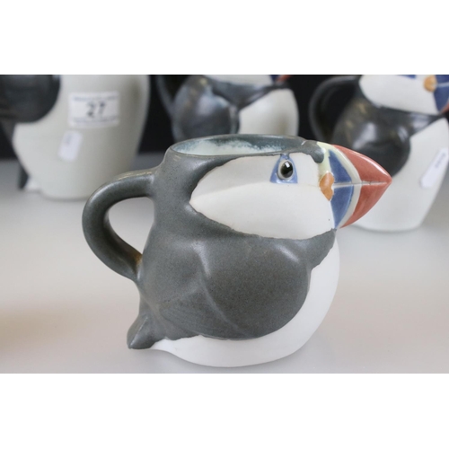 27 - John O'Groats Pottery - Set of Three Graduating Puffin Jugs, largest 20cm high together with another... 