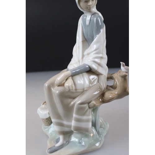 55 - Lladro Figurine of a Girl sat on a tree stump with picnic basket and bird, 26cm high