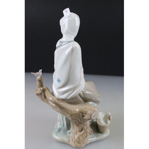 55 - Lladro Figurine of a Girl sat on a tree stump with picnic basket and bird, 26cm high