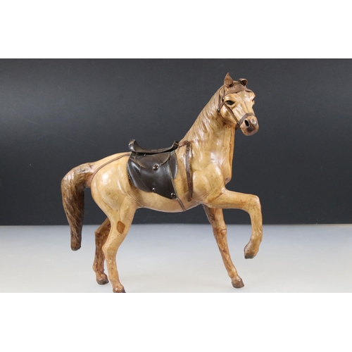 83 - Four leather horse models, with saddles and harnesses, tallest 32cm