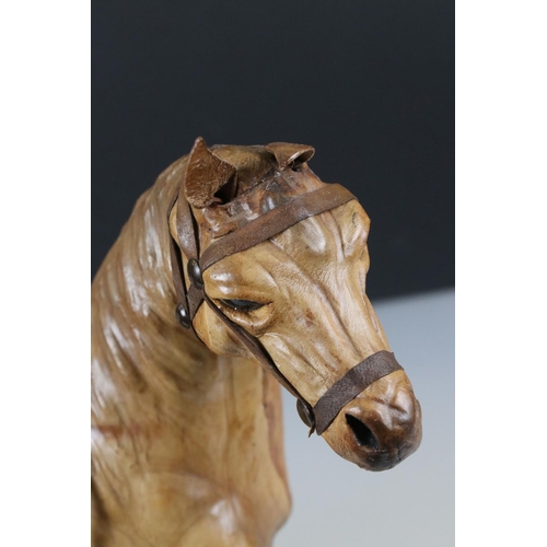 83 - Four leather horse models, with saddles and harnesses, tallest 32cm