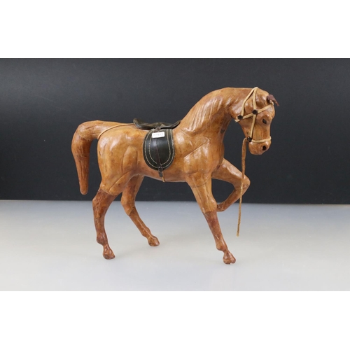 83 - Four leather horse models, with saddles and harnesses, tallest 32cm