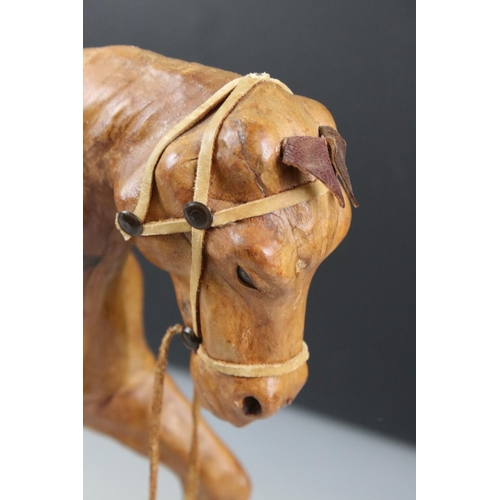 83 - Four leather horse models, with saddles and harnesses, tallest 32cm