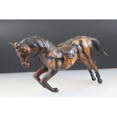 83 - Four leather horse models, with saddles and harnesses, tallest 32cm